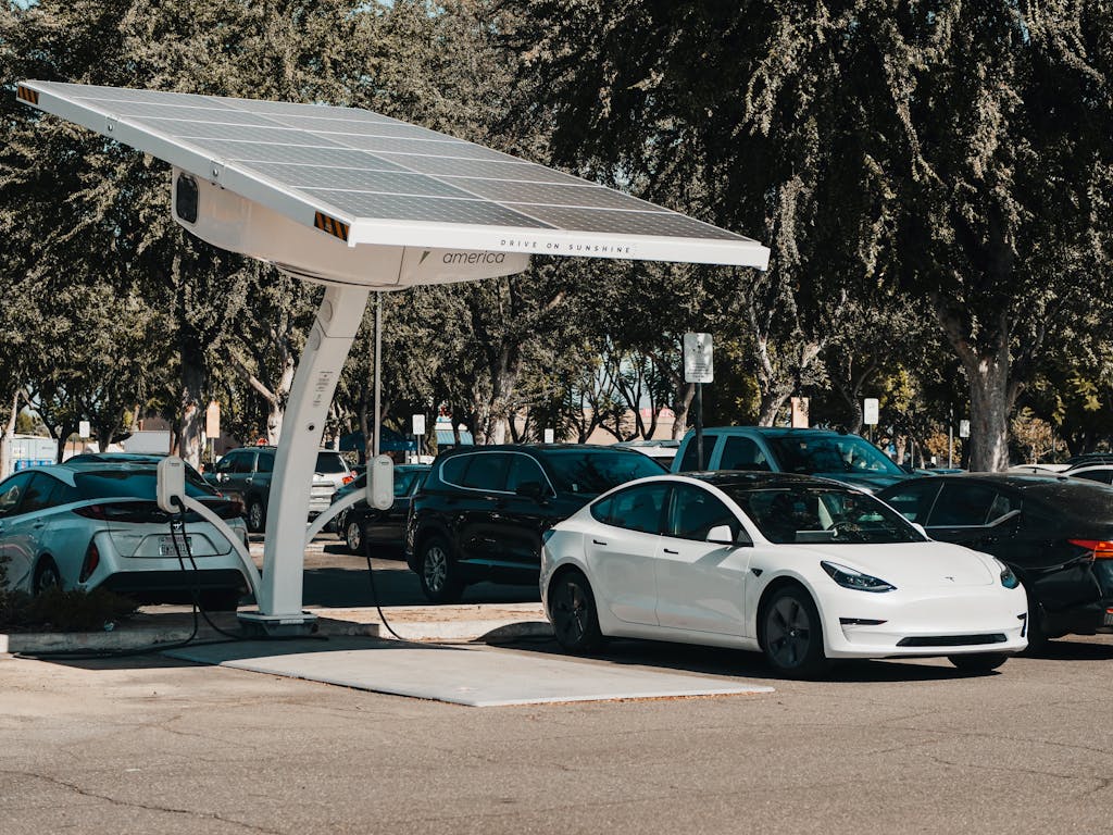 Photo by Kindel Media Electric car parked at a solar charging station outdoors, highlighting renewable energy and innovation.