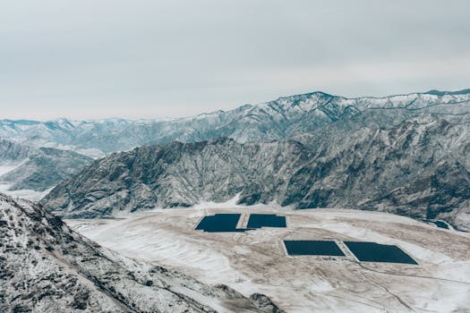 pexels-photo-7456229-7456229 Aerial view of a snow-covered mountain landscape with solar panels.