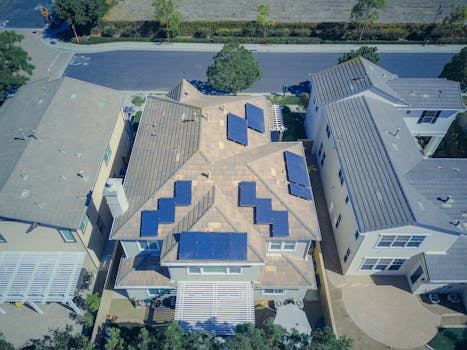 Aerial view of suburban homes equipped with solar panels in a sunny neighborhood.