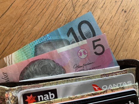 pexels-photo-7654007-7654007 Close-up of Australian dollar bills and credit cards in a wallet on a wooden surface.