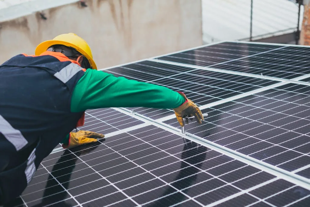 Photo by Los Muertos Crew Technician installing solar panels on a rooftop for sustainable energy solutions.